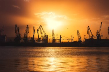 Varna, Bulgaristan 'da deniz limanı ve sanayi turnaları. Varna Gölü üzerinde gün batımı.