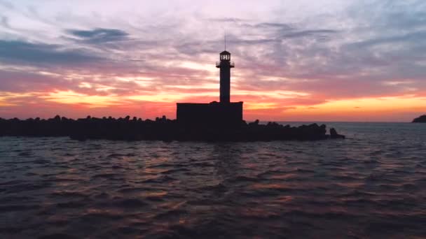 Φάρο Σιλουέτα Στη Θάλασσα Στο Ηλιοβασίλεμα — Αρχείο Βίντεο