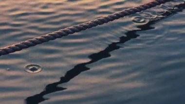 Su dokusu olarak dalgalanan deniz dalgaları ve çapa halatı