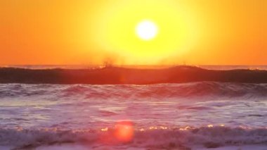 Deniz dalgaları üzerinde altın gün doğumu