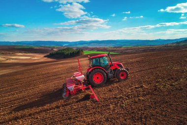 Traktördeki çiftçi gelecek yıl için fidelerle tarım arazisi hazırlıyor.