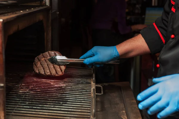 Chef roasts meat steak — Stock Photo, Image