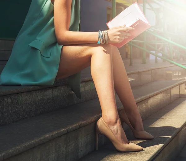 Woman with beauty leg holding a book — Stock Photo, Image
