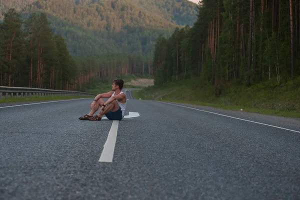 Homem sentado na estrada — Fotografia de Stock