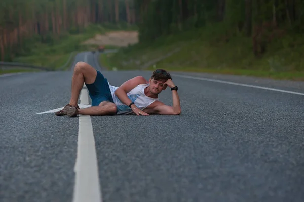 Чоловік лежить на дорозі — стокове фото