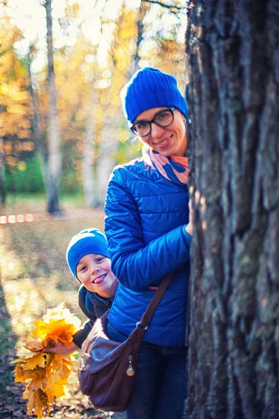 Mulher de beleza e seu filho no parque de outono — Fotografia de Stock