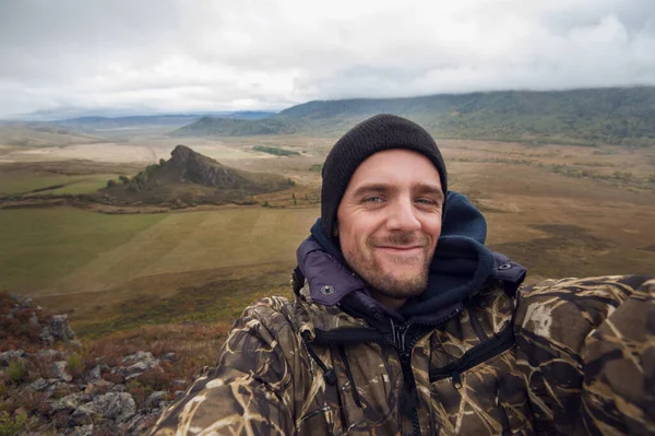 Homem caucasiano na montanha fazendo selfie — Fotografia de Stock