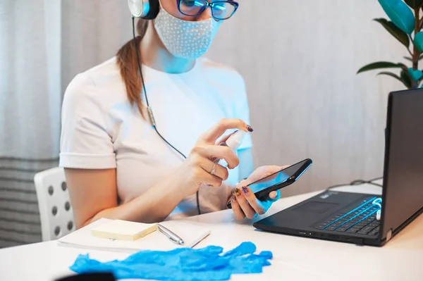 Mujer desinfecta la superficie del teléfono —  Fotos de Stock