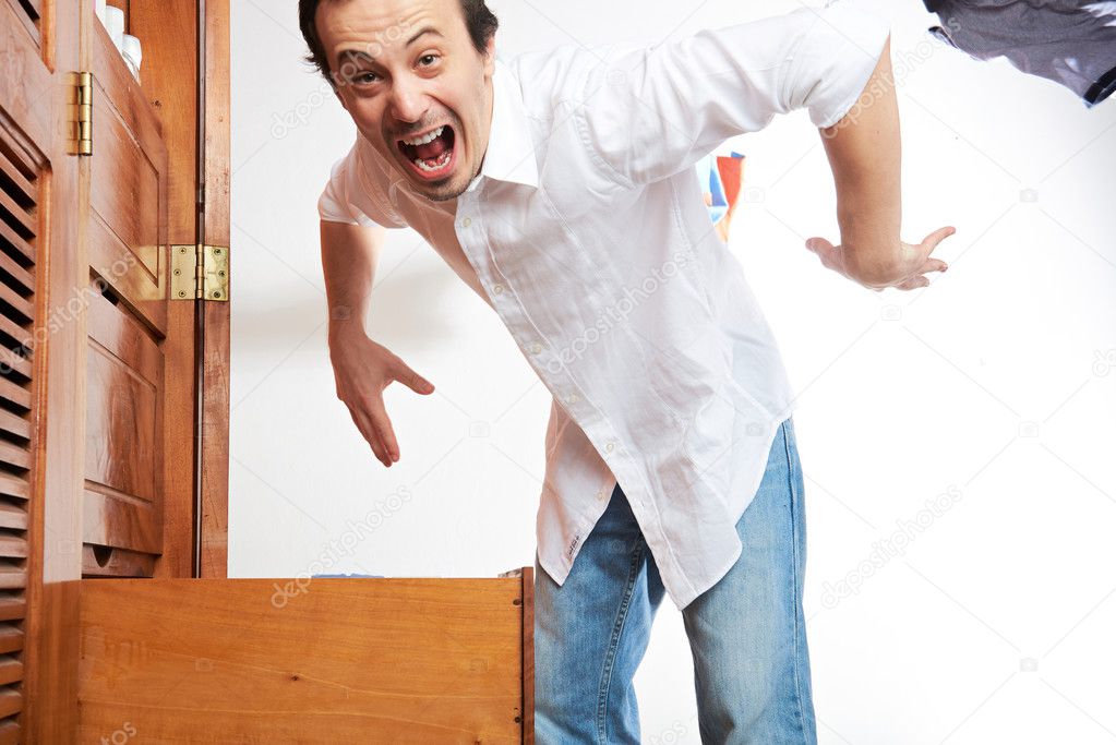 angry young man throwing clothes