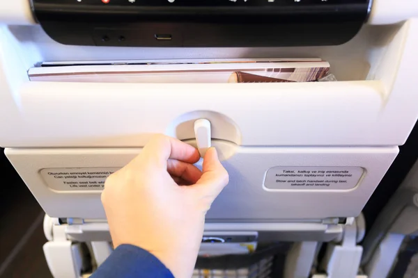 Hand locking white passenger airplane table — Stock Photo, Image