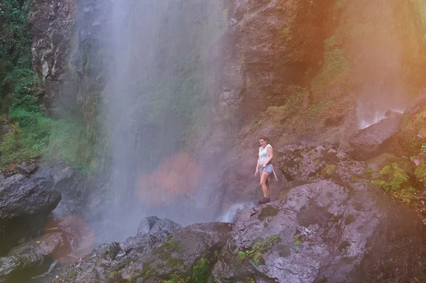 woman hiking next to water fall