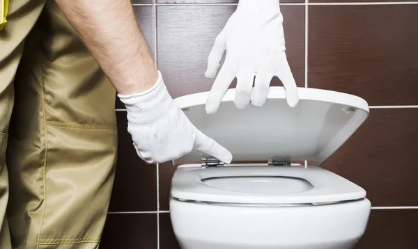 Plumber showing problem area of toilet — Stock Photo, Image