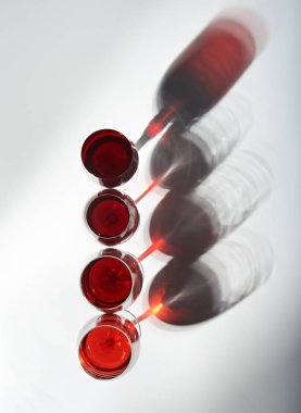 Gölgelerin içinden kırmızı şarap bardakları