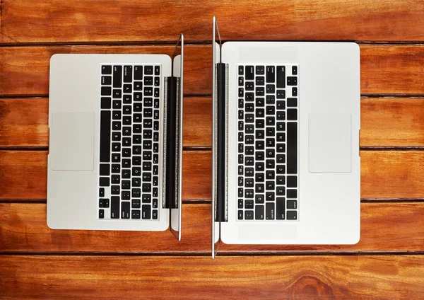 Δύο σύγχρονες φορητοί υπολογιστές σε ξύλινο τραπέζι — Φωτογραφία Αρχείου