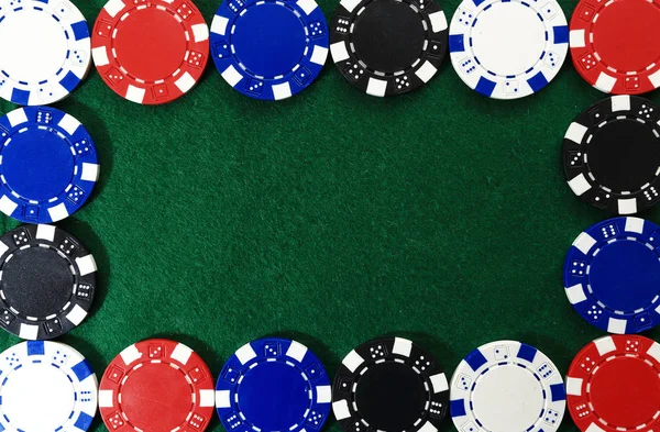 Frame of poker chips on green background