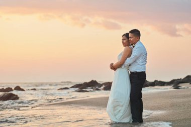 Damat gelini günbatımı kumsalda sarılmak