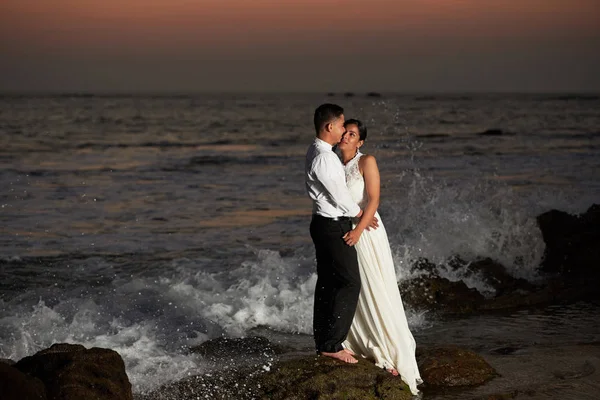 Noiva e noivo stand na praia — Fotografia de Stock