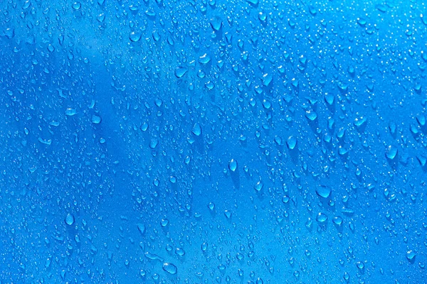 Wassertropfen auf blauem Metallhintergrund — Stockfoto