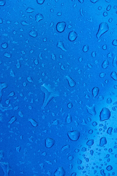 Regentropfen auf metallblauer Oberfläche — Stockfoto