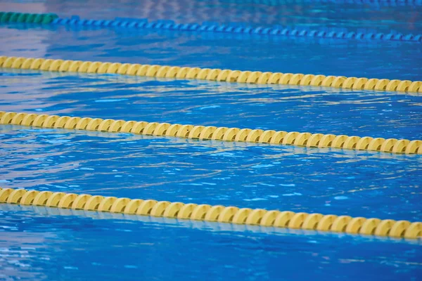 Gelbe Bahnen im blauen Poolwasser — Stockfoto