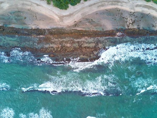Zöld víz megüt a sziklák beach — Stock Fotó