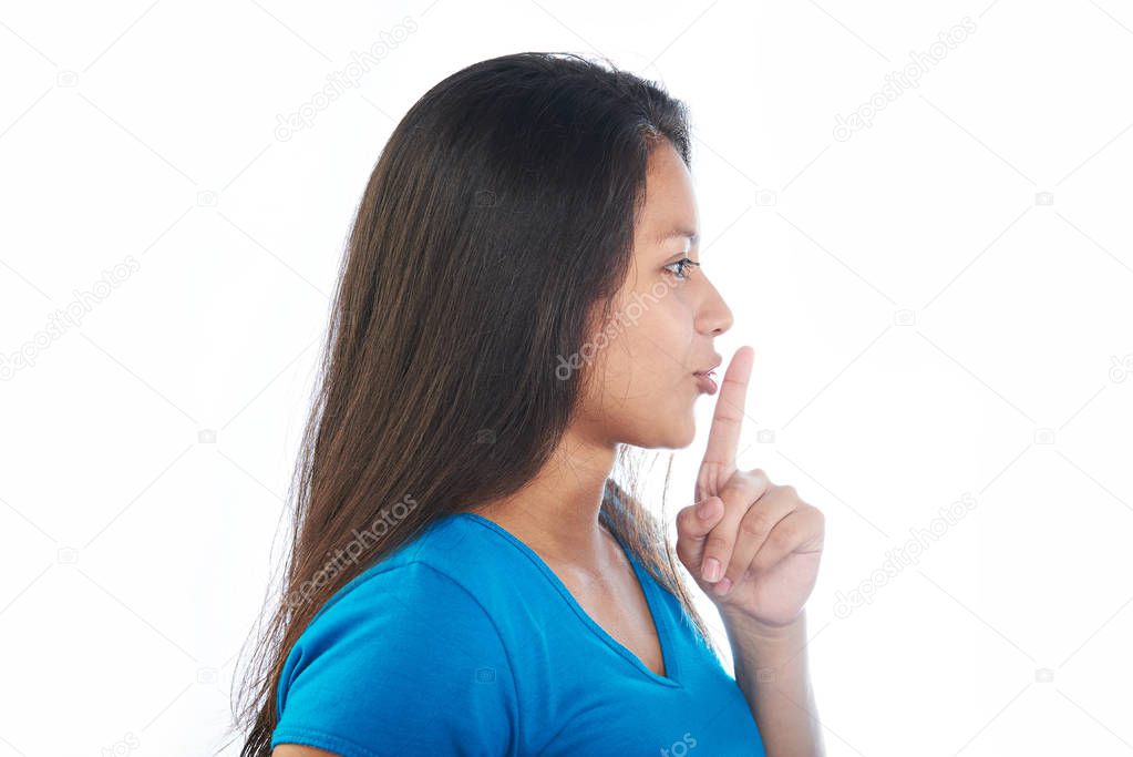 Young girl making shh gesture