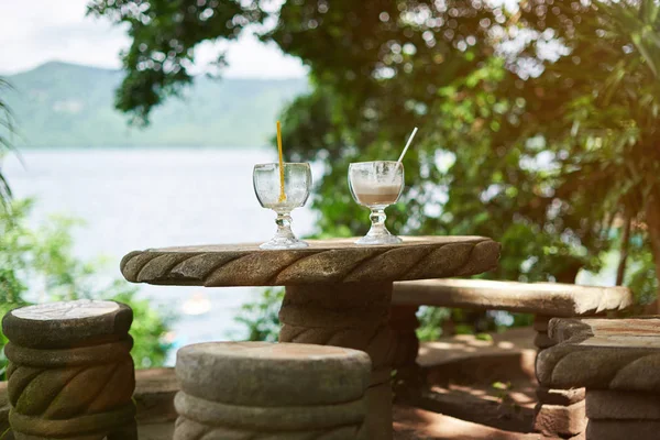 Mesa de pedra com dois copos de bebida — Fotografia de Stock