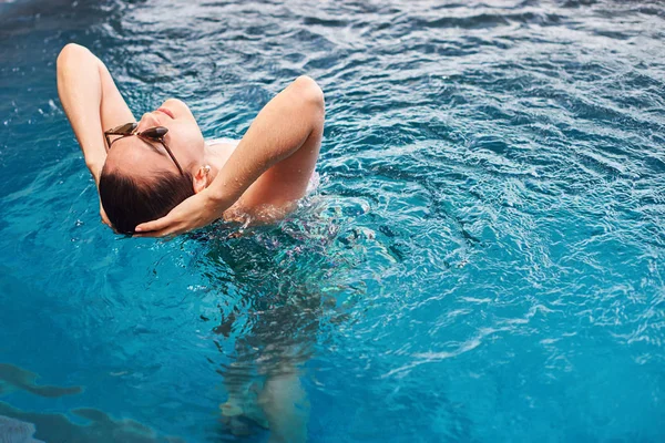 Kobieta, ciesząc się niebieska woda w basenie — Zdjęcie stockowe