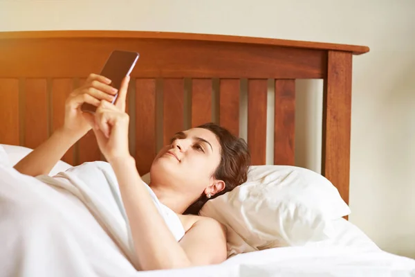 Kvinna textning om i sängen — Stockfoto