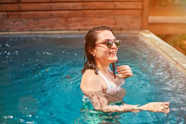 Mulher morena sorridente na água da piscina — Fotografia de Stock