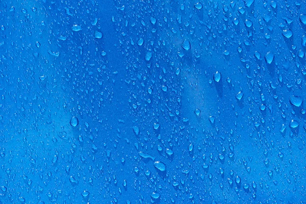Dešťové kapky na modré kovové pozadí — Stock fotografie