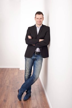 Kollarını kavuşturmuş gülümseyen adam. 