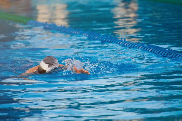 Mannen bad i blå poolvatten i — Stockfoto