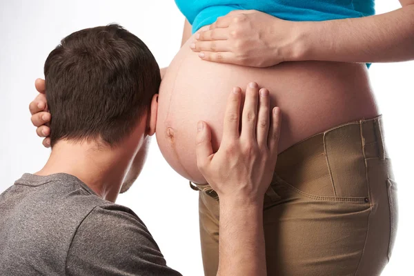 Uomo mettere l'orecchio alla donna incinta pancia — Foto Stock