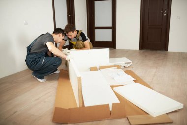 İki profesyonel işçi dairede mobilya yükleme