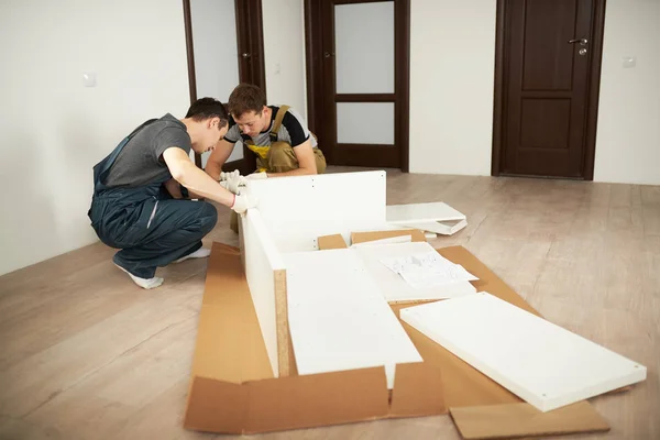 Two professional workers installing furniture in apartment — Stock Photo, Image