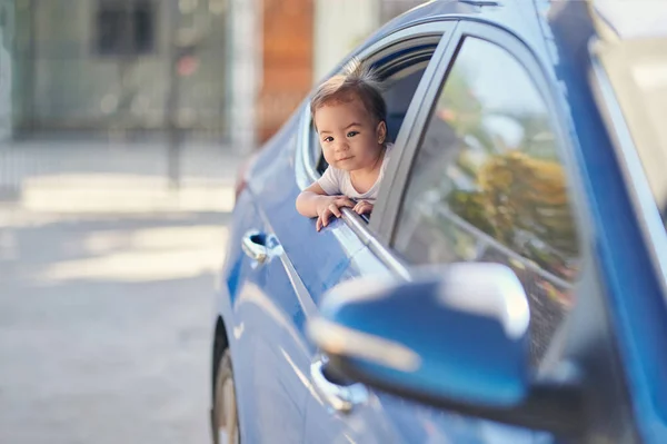 เด็กที่มีความสุขบนหน้าต่างเบาะหลังรถ — ภาพถ่ายสต็อก