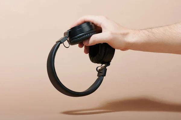 Macro of hand holding black headphones — Stock Photo, Image