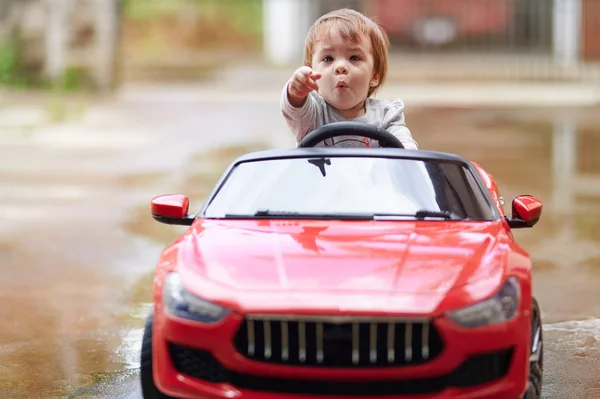 Niña pequeña sentarse en el coche y punto — Foto de Stock