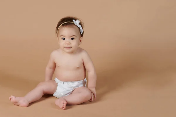 Menina sentada no fundo do estúdio — Fotografia de Stock