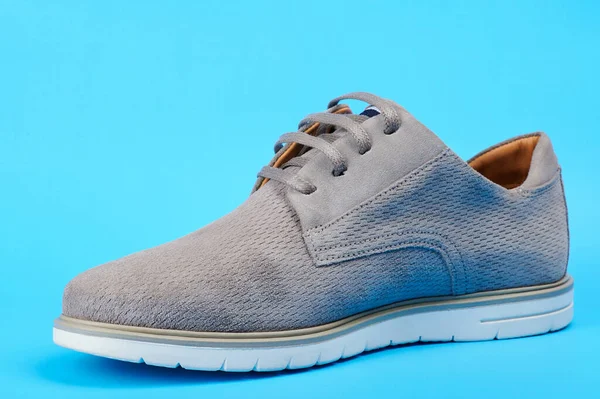 One man gray casual shoe isolated on blue background