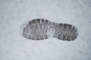 Karda ayak izi var. Yakın plan görüntüde. Kış ayakkabısının işareti.