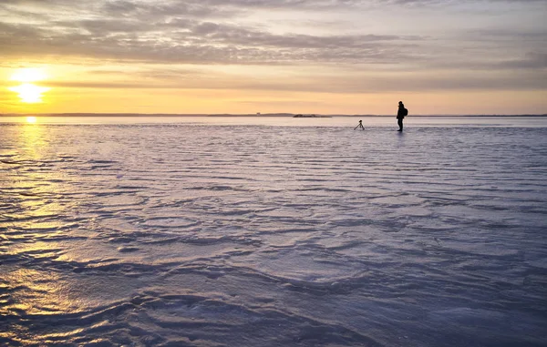 Fotograf Robi Zdjęcia Zamarzniętym Jeziorze Tle Zachodzącego Słońca — Zdjęcie stockowe