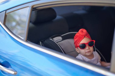 Araba koltuğundaki Arap bebek pencereden dışarı bakıyor