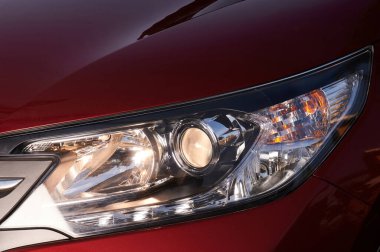 Modern kırmızı arabanın farları yakın görüntüde.