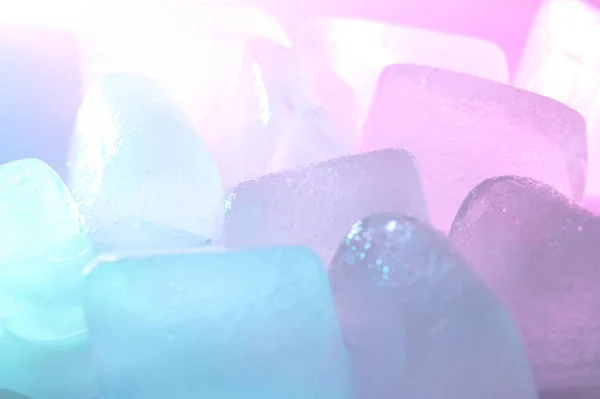 蓝光和紫光背景上干净冰块的近景 — 图库照片