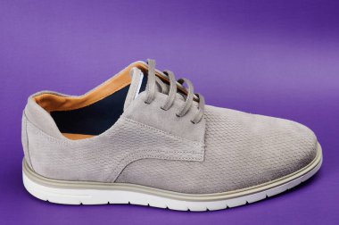 Mor arka planda izole edilmiş gri günlük erkek ayakkabısı görünümü