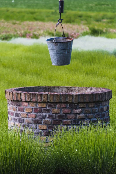 Eimer mit rostigem Eisenwasser über einem Brunnen — Stockfoto