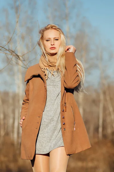 Beautiful girl in a coat posing against the background of a spring nature — Stock Photo, Image