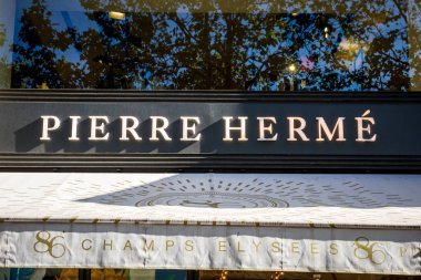 Paris/France - September 10, 2019 : The Pierre Herme pastry store entrance sign on Champs-Elysees avenue